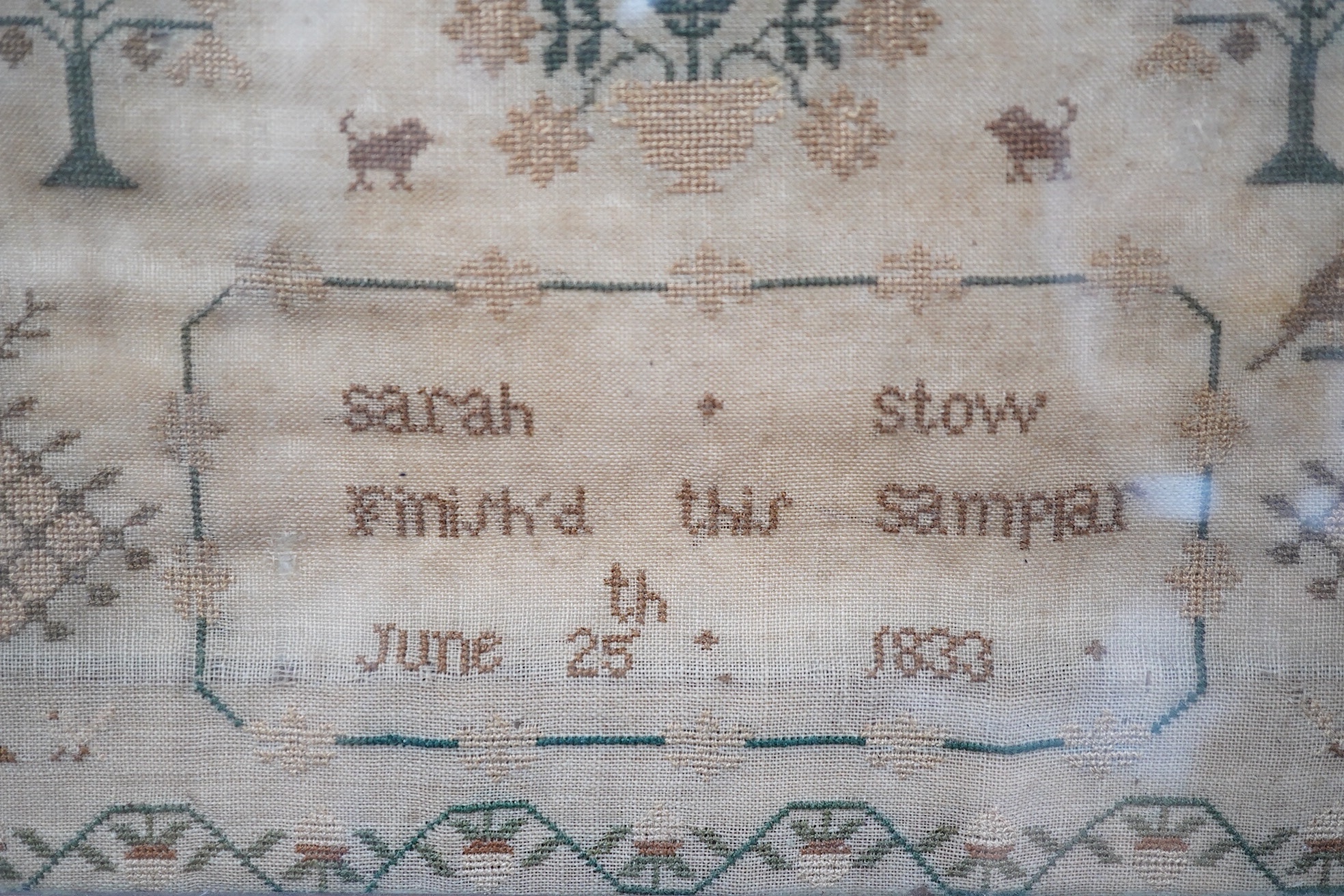 A spot motif and verse sampler, by Sarah Stow dated 1833, worked in multi-coloured silks, with a vineous border, a row of alphabet letters with a wide panel of spot motifs of birds and flowers above an embroidered verse